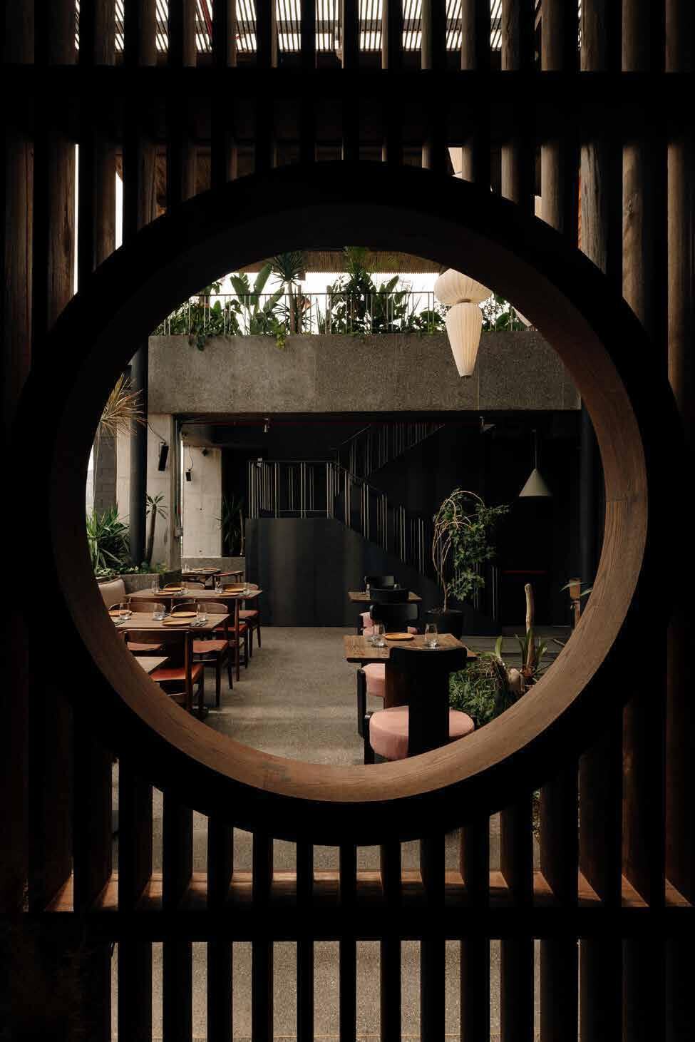 Circular timber screen framing the dining room at Mal de Ojo