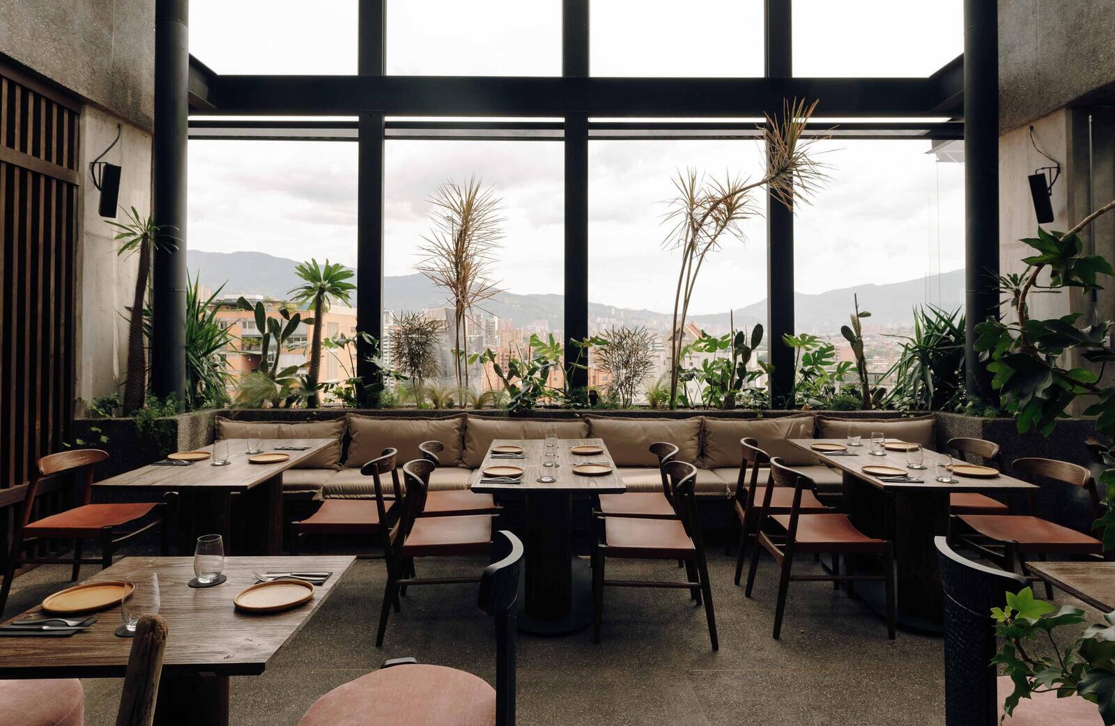 Mal de Ojo dining room with full-height windows over Medellín