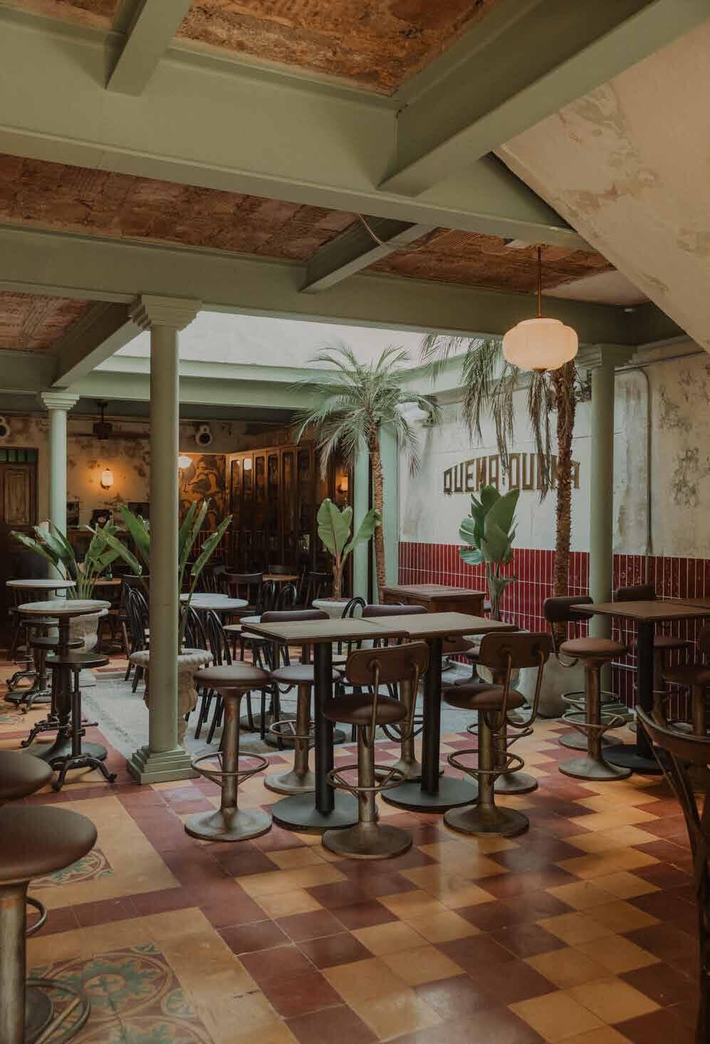 Dining area at Quema que Quema with green columns and patterned floor