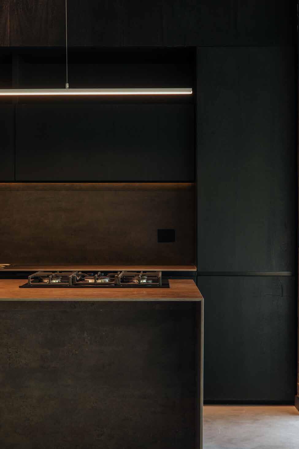Dark kitchen with linear pendant at Casa S